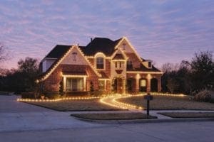 Home decorated with Christmas lights on the frame and through the yard