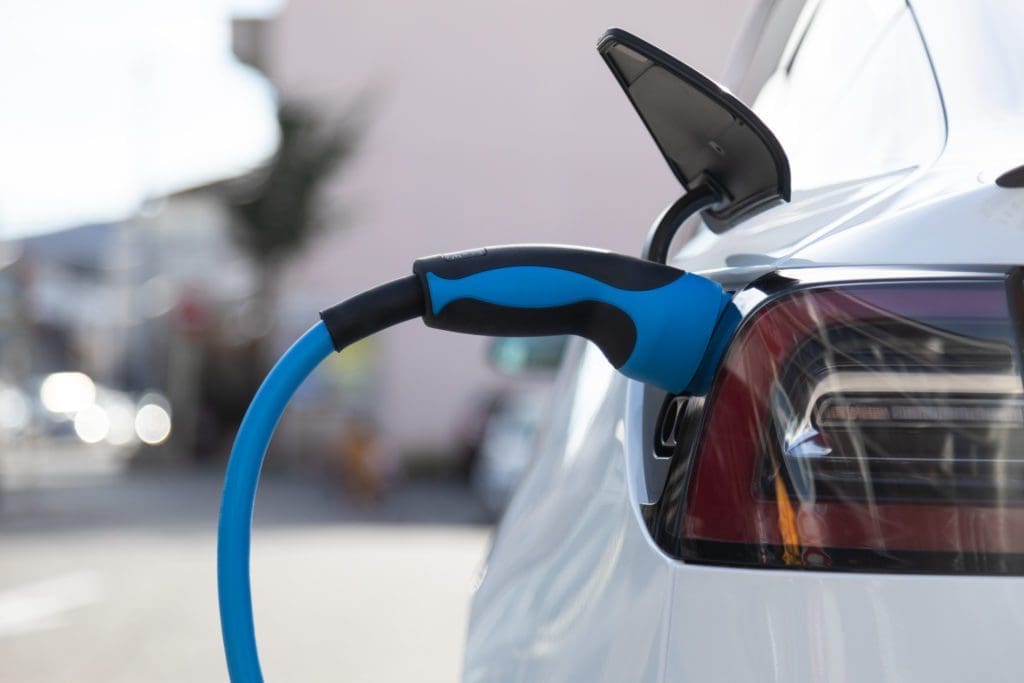 EV electric car plugged charging at a recharge station in the city